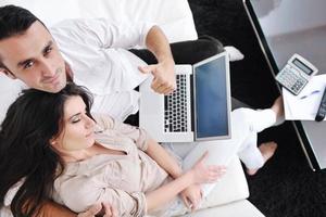 joyful couple relax and work on laptop computer at modern home photo