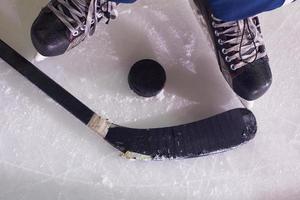 hockey sticsk and puck on ice photo