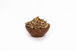 hierbas ayurvédicas o medicina popular hemidesmus indicus o nannari o zarzaparrilla india raíces secas en cuenco de madera foto