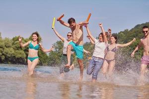 grupo de amigos felices divirtiéndose en el río foto