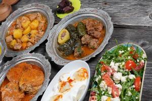 Eid Mubarak Traditional Ramadan Iftar dinner. Assorted tasty food in authentic rustic dishes on wooden table background. photo