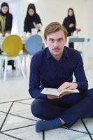 Young muslim man reading Quran during Ramadan photo