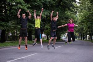 runners team jumping in the air during  morning training photo