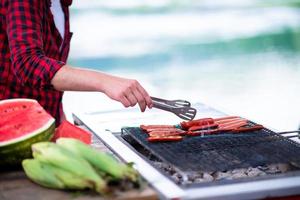 Man cooking tasty food on barbecue grill photo