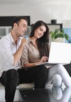 joyful couple relax and work on laptop computer at modern home photo