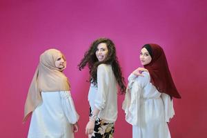 Young muslim women posing on pink background photo