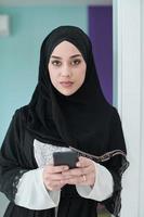 Portrait of Arab woman in traditional clothes using mobile phone. photo