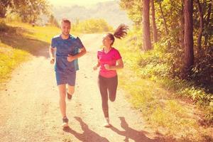 young couple jogging on sunny day at nature photo