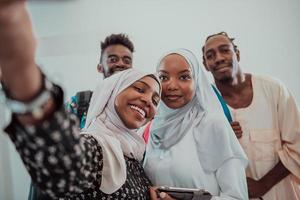 A group of multiethnic students take a selfie with a smartphone on a white background. Selective focus photo