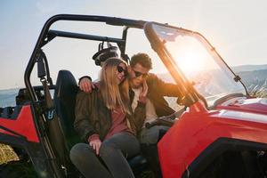 pareja disfrutando de un hermoso día soleado mientras conduce un buggy todoterreno foto