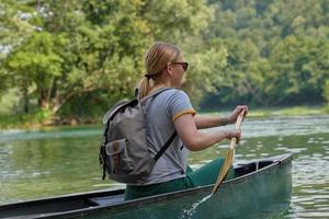 woman adventurous explorer are canoeing in a wild river photo