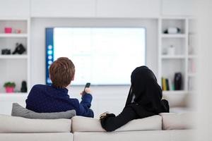 young muslim couple watching TV together photo