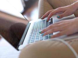 relaxed young woman at home working on laptop computer photo