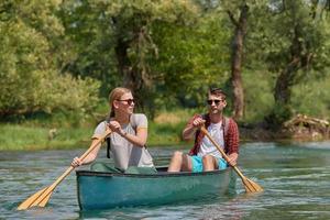 friends are canoeing in a wild river photo