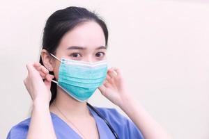 Asian female doctor is wearing medical  face masks to protect from Coronavirus-19 COVID-19 in healthcare and new normal concept. photo