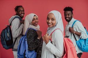 un grupo de estudiantes musulmanes africanos con mochilas posando sobre un fondo rosa. el concepto de educación escolar. foto