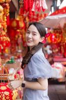 Asian beautiful woman in grey dress smiles in Chinese New Year theme as background. photo