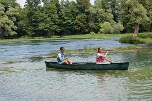 friends are canoeing in a wild river photo