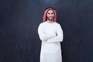 retrato de un hombre árabe frente a una pizarra negra foto