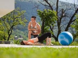 woman with personal trainer doing morning yoga exercises photo