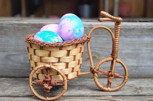 Eggs for Easter in a blue basket on a wooden background close-up with the addition of ears, view from the top photo