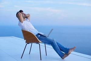 relaxed young man at home on balcony photo