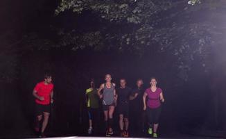 equipo de corredores en el entrenamiento nocturno foto