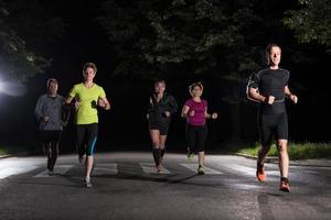 equipo de corredores en el entrenamiento nocturno foto