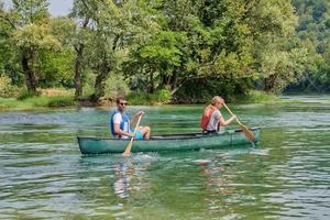 friends are canoeing in a wild river photo