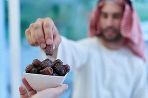 pareja musulmana compartiendo fechas para comenzar el iftar foto