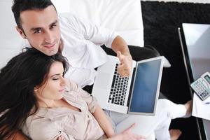 joyful couple relax and work on laptop computer at modern home photo