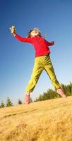 Kid jumping in field photo