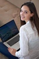 relaxed young woman at home working on laptop computer photo