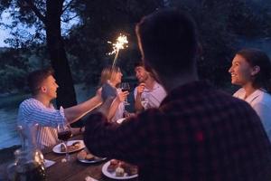 amigos brindando con una copa de vino tinto mientras hacen un picnic cena francesa al aire libre foto