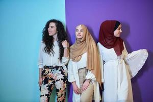 jóvenes musulmanas posando sobre fondo morado y azul foto