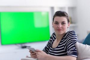 woman on sofa using tablet computer photo