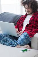 man freelancer in bathrobe working from home photo