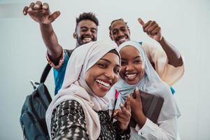 A group of multiethnic students take a selfie with a smartphone on a white background. Selective focus photo