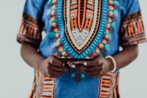 Varón africano nativo de Sudán que usa un teléfono inteligente aislado de fondo blanco. foto