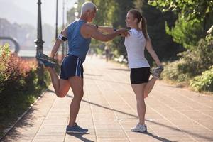 couple warming up and stretching before jogging photo