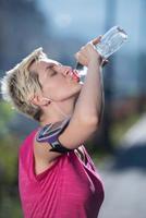 mujer bebiendo agua después de trotar foto