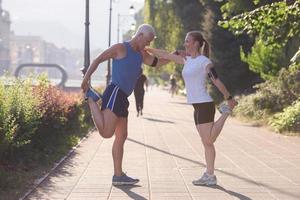 couple warming up and stretching before jogging photo