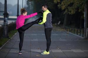 una pareja joven calentando antes de trotar foto