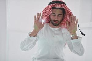 Muslim man doing sujud or sajdah on the glass floor photo