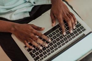 Close-up photo of a man typing on a laptop keyboard. Selective focus