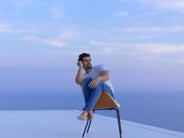 relaxed young man at home on balcony photo