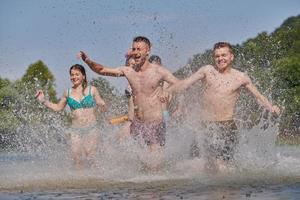 grupo de amigos felices divirtiéndose en el río foto