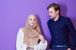 retrato, de, joven, pareja musulmana, aislado, en, púrpura, plano de fondo foto