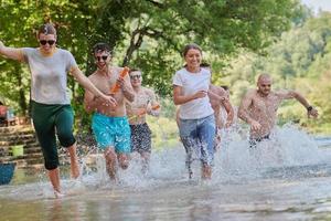 group of happy friends having fun on river photo