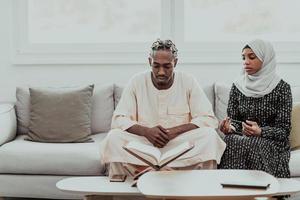 African Muslim couple at home in Ramadan reading Quran holly Islam book. photo